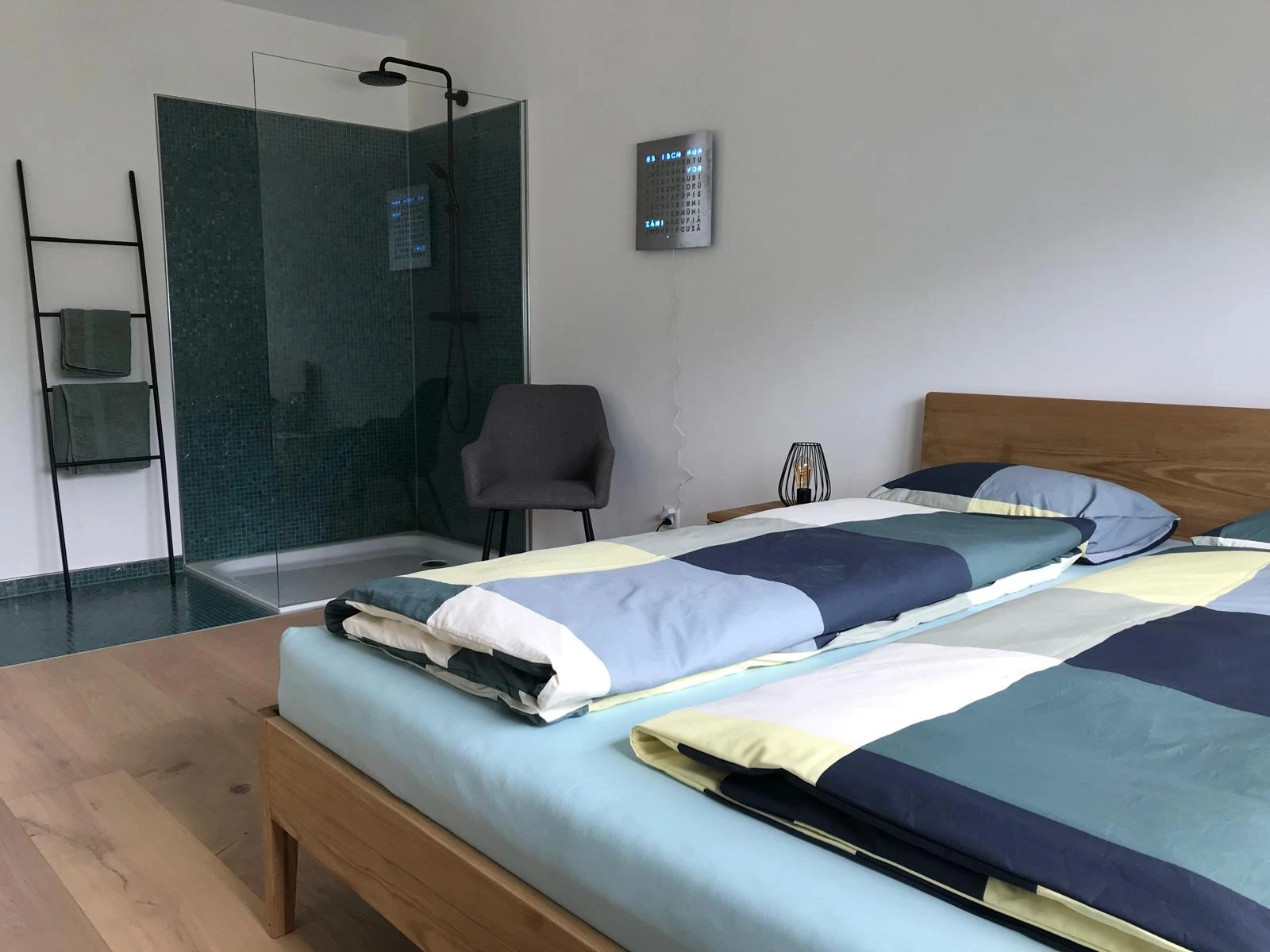 Schlafzimmer mit Doppelbett und Dusche